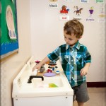 Playing with the shakers at the kitchen station in his classroom
